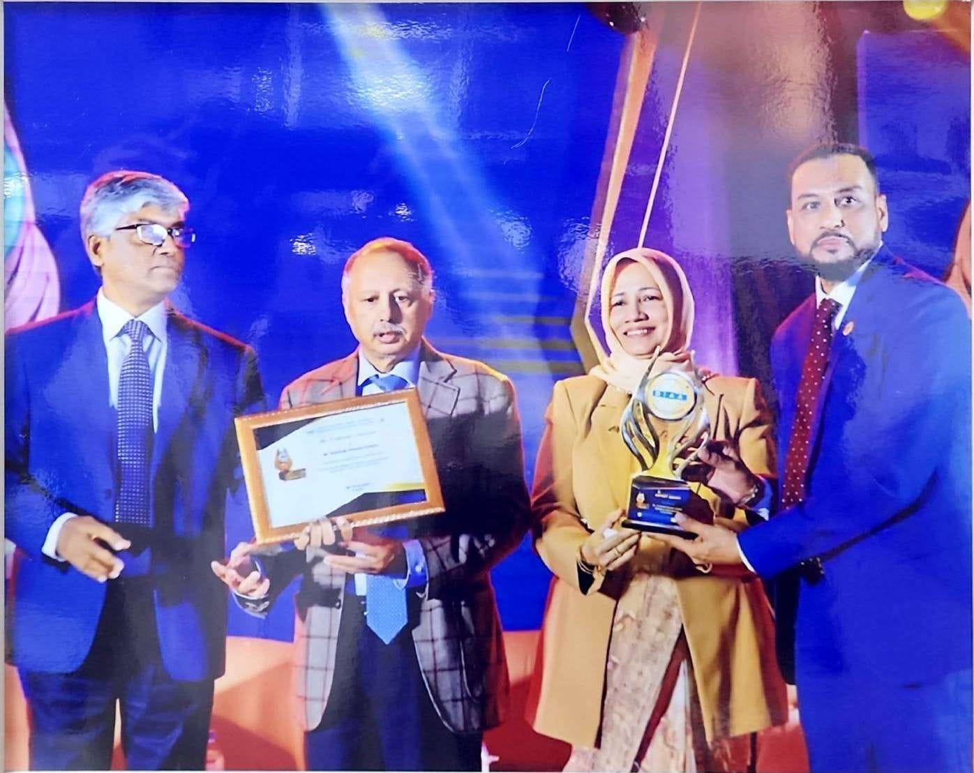 The Bizz 2024 Award - Goldsfine International Ltd. recipient holding trophy, certificate, and medal